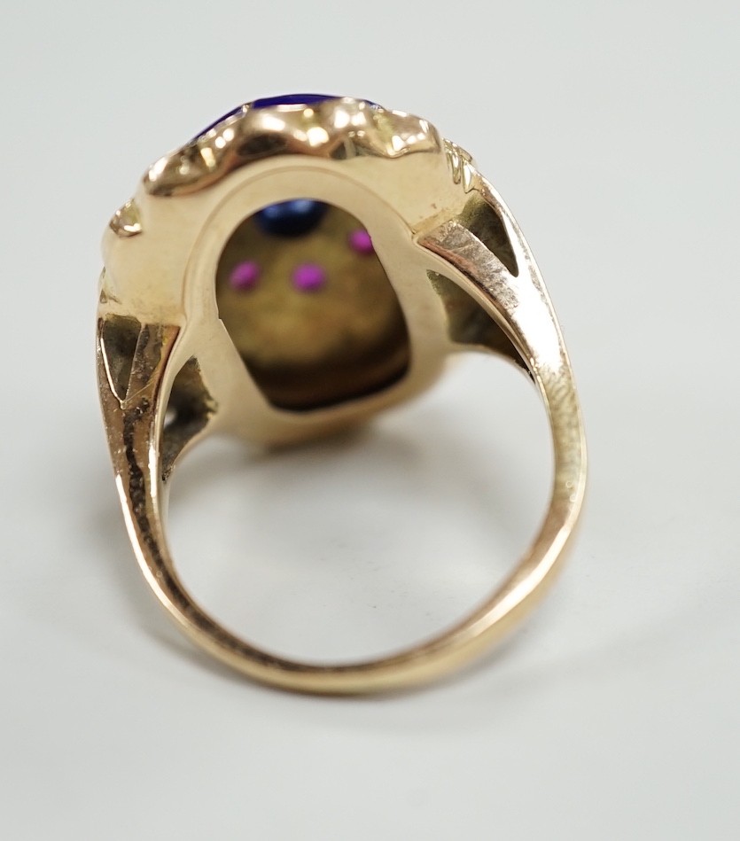 A yellow metal, blue enamel, ruby and cabochon sapphire set oval dress ring, the shank inscribed 'Sister My Sister?' size O, gross weight 13.7 grams.